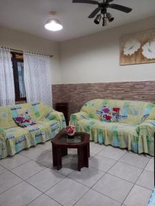 a living room with a couch and a coffee table at Maranata Casa com Piscina - 2 minutos de carro até o mar in Peruíbe