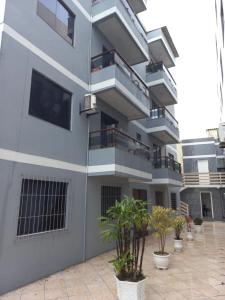 an apartment building with balconies and potted plants at Apartamento 2 quartos em Torres-RS in Torres
