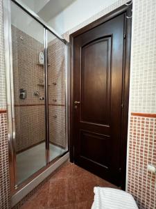 bagno con doccia e porta in legno di OPUNTIA DELL'ETNA BIKE HOUSE a Mascalucia