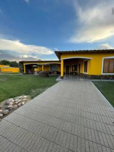 una casa amarilla con una entrada delante de ella en Yellow House en Tunuyán