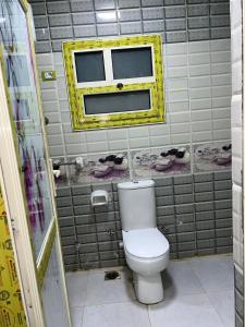 a bathroom with a white toilet and a window at Seror Guest House in Cairo