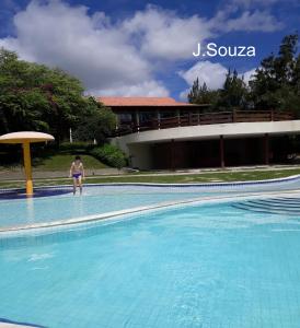 a person standing in the water in a swimming pool at Flat Condomínio Hotel Fazenda Gravatá Monte Castelo in Gravatá