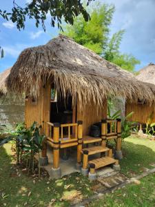 uma pequena cabana com um banco e um telhado de palha em Bali Bio Villas em Uluwatu