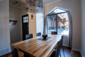 a dining room with a wooden table and a window at Renovated Chalet at Mystic Springs, Pool, Hot Tub! in Canmore