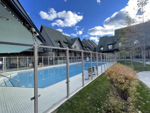 ein Schwimmbad mit einem Zaun um ihn herum in der Unterkunft Renovated Chalet at Mystic Springs, Mountain Views, Pets Welcome! in Canmore