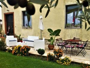 un patio con mesa, sillas y sombrilla en Belvilla by OYO Green Eden, en Lucignano
