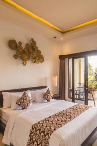 a bedroom with a large bed and a balcony at Divara Ubud in Ubud