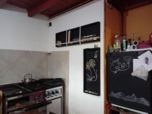 cocina con fogones y nevera negra en La Casita de Carla en Quequén