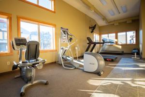 a gym with several tread machines in a room with windows at Renovated Condo, 2BR, 2BA, Heated Pool, 3 Hot Tubs, Pets Welcome! in Canmore