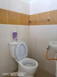 Simple Home by Aimie Fully Aircond في دونجون: حمام به مرحاض أبيض ومغسلة