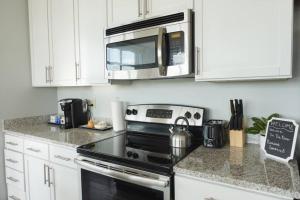 a kitchen with a stove and a microwave at Luxury Downtown Apartment with Balcony! in Greenville