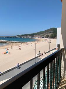 balcone con vista su una spiaggia con persone di Casa vista Azul a Sesimbra