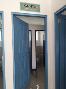 a blue door leading into a bathroom with a toilet at Anjo Maumere Hotel & Restaurant in Nangalima
