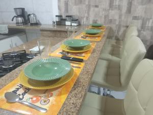 una cocina con una mesa con platos verdes. en charmoso apto Centro de Curitiba, en Curitiba