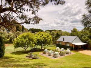 una casa con un grupo de sillas en el césped en Elevation652 at Mt Bellevue in King Valley, en Myrrhee