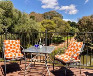 two chairs and a table on a deck with a table and two glasses at Elevation652 at Mt Bellevue in King Valley in Myrrhee