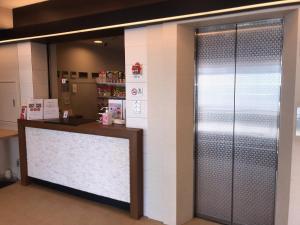 una puerta de metal en una tienda con un mostrador en Stay Inn Will en Saitama