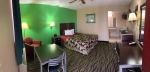 Thunderbird Inn في ليبرال: غرفه فندقيه بسرير وجدار اخضر