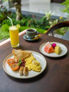 two plates of breakfast food on a table with a drink at Divara Ubud in Ubud