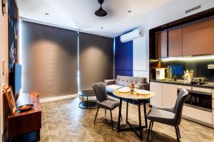 a kitchen and living room with a table and chairs at Scarletz Suites KLCC by Mana-Mana in Kuala Lumpur