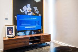 a flat screen tv sitting on top of a wooden entertainment center at Scarletz Suites KLCC by Mana-Mana in Kuala Lumpur