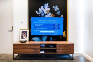 a flat screen tv sitting on top of a wooden entertainment center at Scarletz Suites KLCC by Mana-Mana in Kuala Lumpur