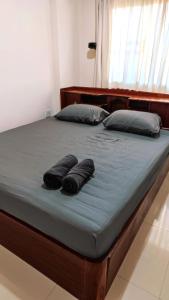 Una cama con dos almohadas encima. en Big whole peaceful house, en Udon Thani