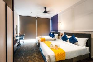a hotel room with two beds and a desk at Scarletz Suites KLCC by Mana-Mana in Kuala Lumpur