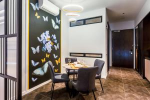 a dining room with a table and chairs and butterflies on the wall at Scarletz Suites KLCC by Mana-Mana in Kuala Lumpur