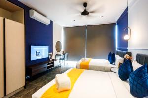 a hotel room with two beds and a flat screen tv at Scarletz Suites KLCC by Mana-Mana in Kuala Lumpur