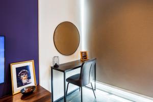 a table with a chair and a mirror on a wall at Scarletz Suites KLCC by Mana-Mana in Kuala Lumpur