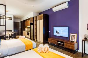 a bedroom with a large bed and a tv at Scarletz Suites KLCC by Mana-Mana in Kuala Lumpur