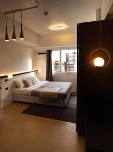 a bedroom with a bed and a window at Stylish Studio @AvidaTowersAtria in Iloilo City
