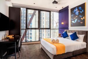 a bedroom with a bed and a desk and a large window at Scarletz Suites KLCC by Mana-Mana in Kuala Lumpur