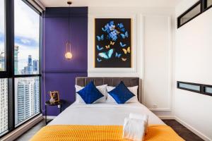 a bedroom with purple walls and a bed with blue pillows at Scarletz Suites KLCC by Mana-Mana in Kuala Lumpur