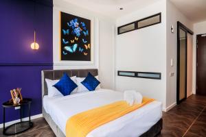 a bedroom with a large bed with blue walls at Scarletz Suites KLCC by Mana-Mana in Kuala Lumpur