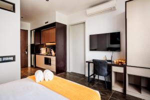 a bedroom with a bed and a desk and a kitchen at Scarletz Suites KLCC by Mana-Mana in Kuala Lumpur