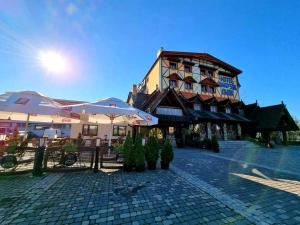 a building with umbrellas next to a cobblestone street at Hotel Marysin Dwór in Katowice