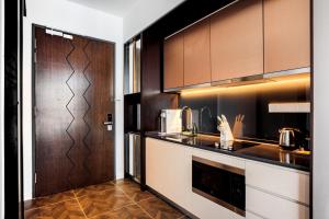 a kitchen with brown cabinets and a counter top at Scarletz Suites KLCC by Mana-Mana in Kuala Lumpur