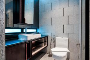 a bathroom with a white toilet and a sink at Scarletz Suites KLCC by Mana-Mana in Kuala Lumpur