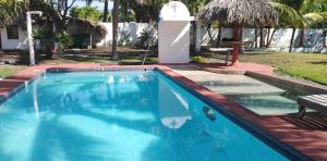une piscine bleue avec une fontaine dans l'établissement Villa Tortugas, à Monterrico