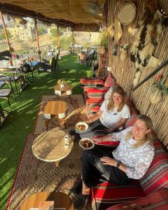 two women sitting on a couch in a tent at Al Misfah Hospitality Inn in Misfāh