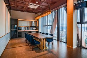 a dining room with a table and chairs and windows at Scarletz Suites KLCC by Mana-Mana in Kuala Lumpur