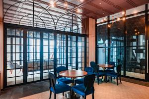 a room with two tables and blue chairs and windows at Scarletz Suites KLCC by Mana-Mana in Kuala Lumpur
