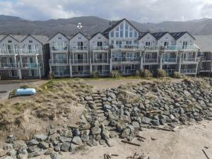 a large building on the beach with a pile of rocks at Rockaway beach vibes,Waterfront Oceanfront Rockaway Beach House near Downtown,WIFI, Washer Dryer in Rockaway Beach