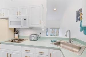 a kitchen with white cabinets and a sink at Cannon beach vibes, steps to the beach,WIFI,3 full bedroom en suites with 3 fireplaces,Near Downtown in Cannon Beach