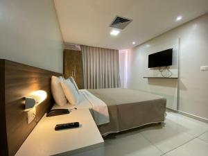 a hotel room with a bed and a tv at Bela Hospedagem - Imperial Flat - Beira mar de Tambaú in João Pessoa