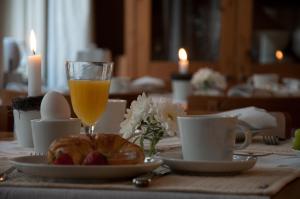 uma mesa com um prato de comida e um copo de sumo de laranja em Hotel am Hoken em Quedlinburg