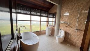 a bathroom with a tub and a shower and a toilet at SANKARA GARDEN in Pantai +85 photos