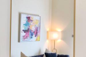 uma sala de estar com um sofá e uma pintura na parede em 2 Bedroom Old Town Garden Apartment - The 108 Residences em Dubai